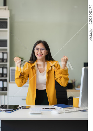 Portrait of a successful business woman with inspiration from their excellent financial results front at the desk, looking to camera. 120808174