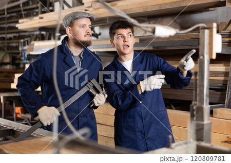 Foreman gives instructions to worker at furniture factory 120809781