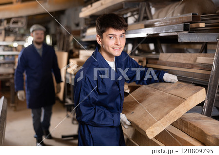 Young guy takes wooden board from stack 120809795