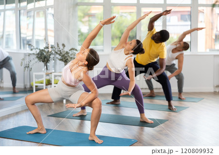 Group of men and women doing pilates in studio 120809932