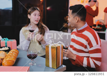 Group of happy Asian friends celebrating Christmas and decorate the Christmas tree indoors. Beauty woman with Christmas Gifts. New Year party. Woman hands decorate Christmas tree red ball, bauble. Group of happy Asian friends celebrating Christmas and decorate the Christmas tree indoors. Beauty woman with Christmas Gifts. New Year party. Woman hands decorate Christmas tree red ball, bauble. 120811931