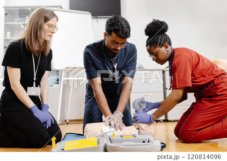Healthcare professionals in scrubs performing medical procedure 120814096