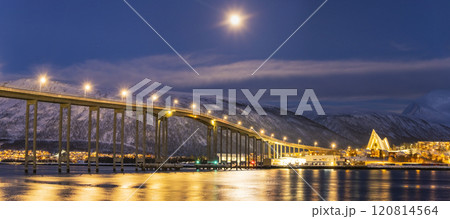 Panorama of the Norwegian city of Tromso on a winter evening during the Christmas season. The bridge over the fjord and houses are illuminated by city lights Panorama of the Norwegian city of Tromso on a winter evening during the Christmas season. The bridge over the fjord and houses are illuminated by city lights 120814564