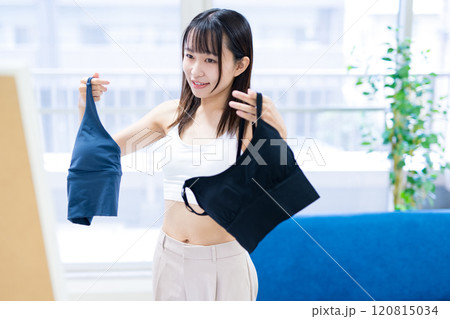 姿見鏡の前で洋服と下着を選ぶ若い女性　スポーツブラ　下着選び　 120815034