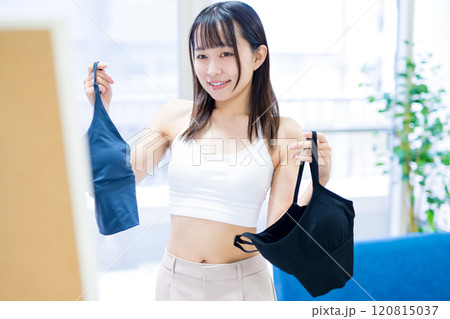 姿見鏡の前で洋服と下着を選ぶ若い女性 スポーツブラ 下着選び 姿見鏡の前で洋服と下着を選ぶ若い女性 スポーツブラ 下着選び 120815037