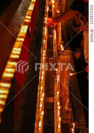 お寺のお線香を灯す人 120815302