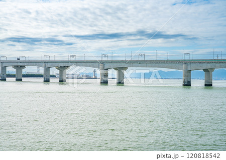りんくう展望ひろば駐車場から見た海にかかるセントレア大橋と名鉄空港線と雲の多い海の風景(愛知県) 120818542