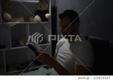 a 30 year old man reading bible and praying in bed with lamp light, evening routine a 30 year old man reading bible and praying in bed with lamp light, evening routine 120819107