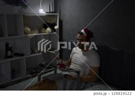 30-year-old man celebrates Christmas, New Year online with colleagues, friends at night with the light of a lamp 30-year-old man celebrates Christmas, New Year online with colleagues, friends at night with the light of a lamp 120819122