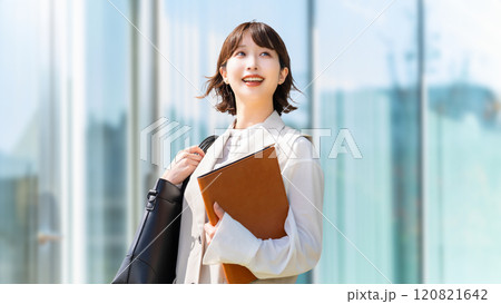 オフィス街を歩く笑顔のビジネスウーマン オフィス街を歩く笑顔のビジネスウーマン 120821642