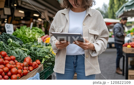Woman browsing tablet in a vegetable market Woman browsing tablet in a vegetable market 120822109