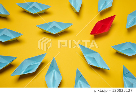 A group of blue paper boats surrounded one red boat, the concept of bullying A group of blue paper boats surrounded one red boat, the concept of bullying 120823127