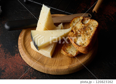 Triangular pieces of cheese and fried ciabatta slices on a wooden board Triangular pieces of cheese and fried ciabatta slices on a wooden board 120823162