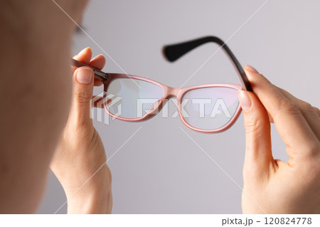 woman putting on glasses for vision close up on white background, concept of good vision 120824778