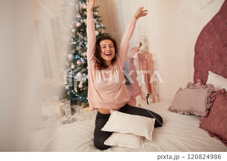 A young girl poses in bed in anticipation of Christmas Eve 120824986