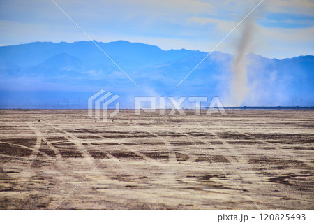 Desert Dust Devil and Mountains with Tire Tracks at Eye Level Perspective 120825493