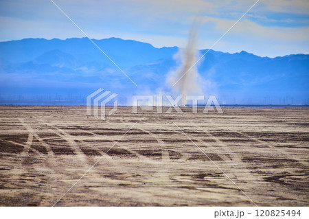 Dust Devil in Arid Desert with Mountain Backdrop Eye Level Perspective 120825494