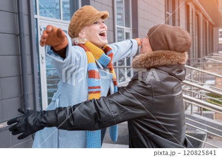 Happy elderly couple embracing outdoors in winter clothes 120825841