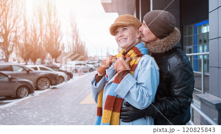 Happy senior couple embracing outdoors in winter city 120825843