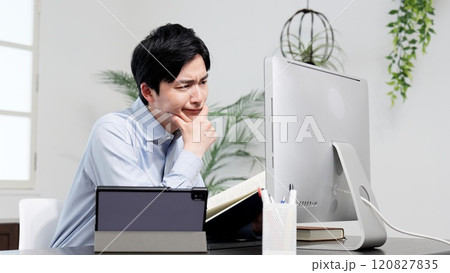 資料を調べてトラブルを解決する男性 資料を調べてトラブルを解決する男性 120827835