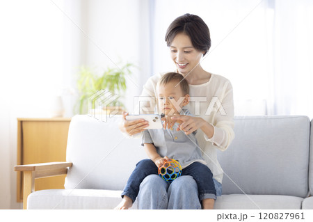 子供にスマートフォンで動画を見せるママ 120827961
