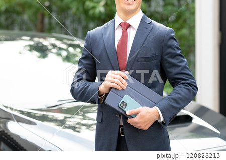 車の前に立つビジネスマン 120828213
