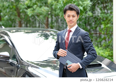 車の前に立つビジネスマン 120828214