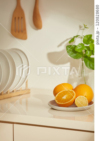 Creative advertising photo template about beige and brown rustic style. A corner of the kitchen cabinets from a high angle shot, decorated with some fruits, green plant vase and disk holders Creative advertising photo template about beige and brown rustic style. A corner of the kitchen cabinets from a high angle shot, decorated with some fruits, green plant vase and disk holders 120828680