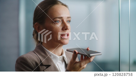 Female marketing manager records voice message in app using smartphone 120828758