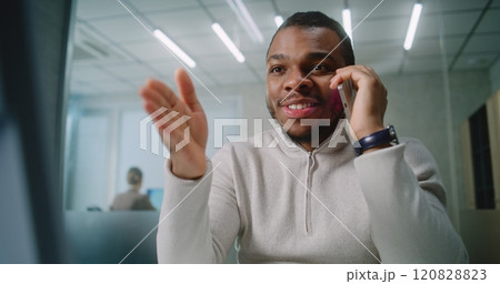 Excited businessman celebrates successful business deal with customer, uses computer Excited businessman celebrates successful business deal with customer, uses computer 120828823