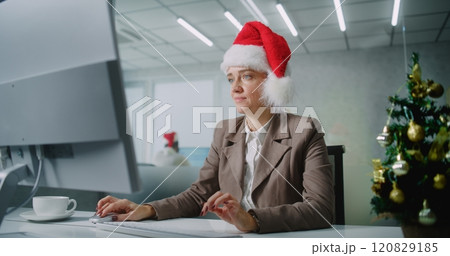 Portrait of successful businesswoman in Christmas hat smiling, looking at camera Portrait of successful businesswoman in Christmas hat smiling, looking at camera 120829185