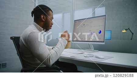 African American E-commerce manager eats food at workplace during lunch break 120829188