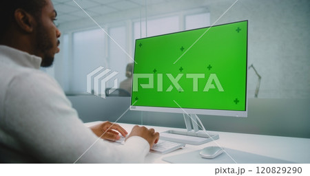 African American financial expert enters data on computer with green screen chromakey 120829290