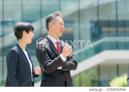 オフィスの前で微笑むビジネスマン達 120830444