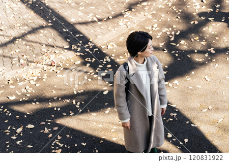 秋の公園でコートを着ている女性 120831922