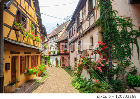 Street with picturesque colorful half-timbered houses in the medieval village of Eguisheim, Alsace, France. Village is ranked in the top 20 of Les Plus Beaux Villages de France. Alsace wine route 120832169