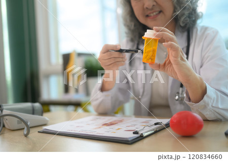 Smiling senior female doctor providing detailed explanations about prescription during a consultation Smiling senior female doctor providing detailed explanations about prescription during a consultation 120834660