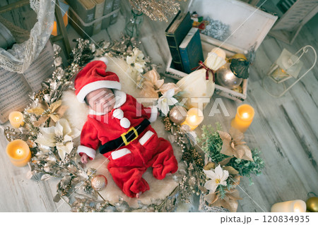 クリスマスにサンタの服を着てニューボーンフォトを撮る生後0か月の新生児の赤ちゃん クリスマスにサンタの服を着てニューボーンフォトを撮る生後0か月の新生児の赤ちゃん 120834935