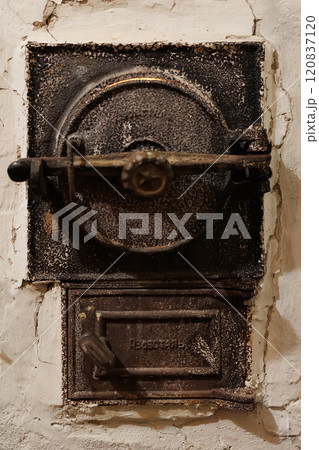 Antique cast iron furnace door with intricate details and a weathered surface 120837120