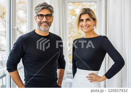 Confident business duo, smiling and standing in a bright modern office with natural light Confident business duo, smiling and standing in a bright modern office with natural light 120837832