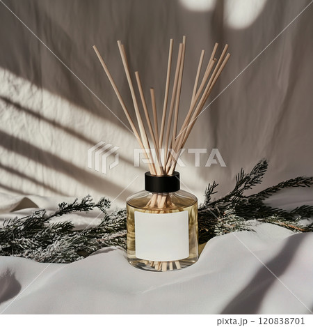 A nicely designed bottle of reed diffuser is resting on a soft white towel. Diffuser white blank label mockup 120838701