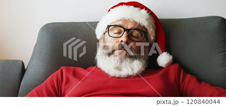 Santa relaxing on a cozy couch 120840044