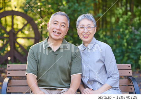 ベンチに座るシニア夫婦 120840229