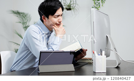 資料を調べてトラブルを解決する男性 資料を調べてトラブルを解決する男性 120840427