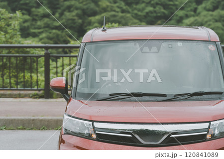 赤い車の運転席に座る若い女性 120841089