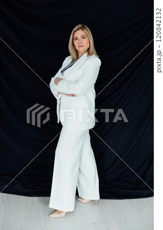 Business woman 45 years old in white business suit on black background 120842132