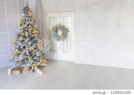 snow Christmas tree with gifts decorated with garlands in the interior for the new year 120842209