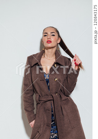 Beautiful slender woman in winter coat on gray background 120843175