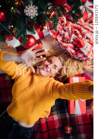 Beautiful woman lying and smiling at christmas tree for new year 120843373