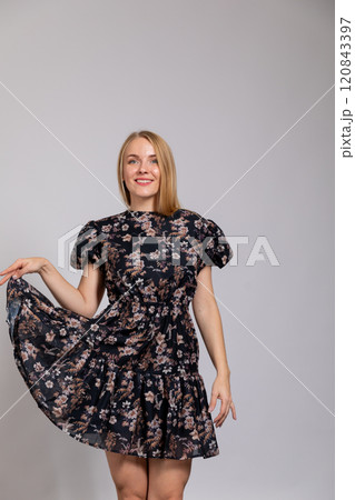 Beautiful woman smiling in summer dress on gray background Beautiful woman smiling in summer dress on gray background 120843397